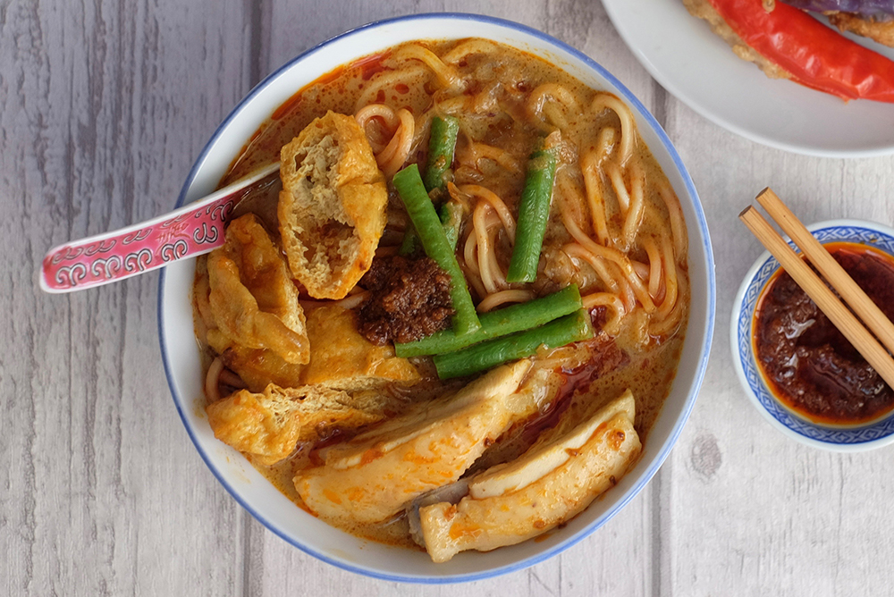 Our homemade curry laksa is served with a side of shrimp sambal belacan 